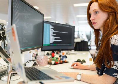 woman in green shirt sitting in front of computer