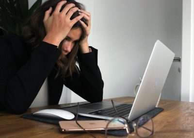 woman in black long sleeve shirt covering her face with her hands