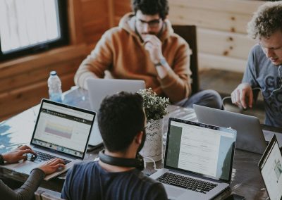 men sitting in front of their laptop computer